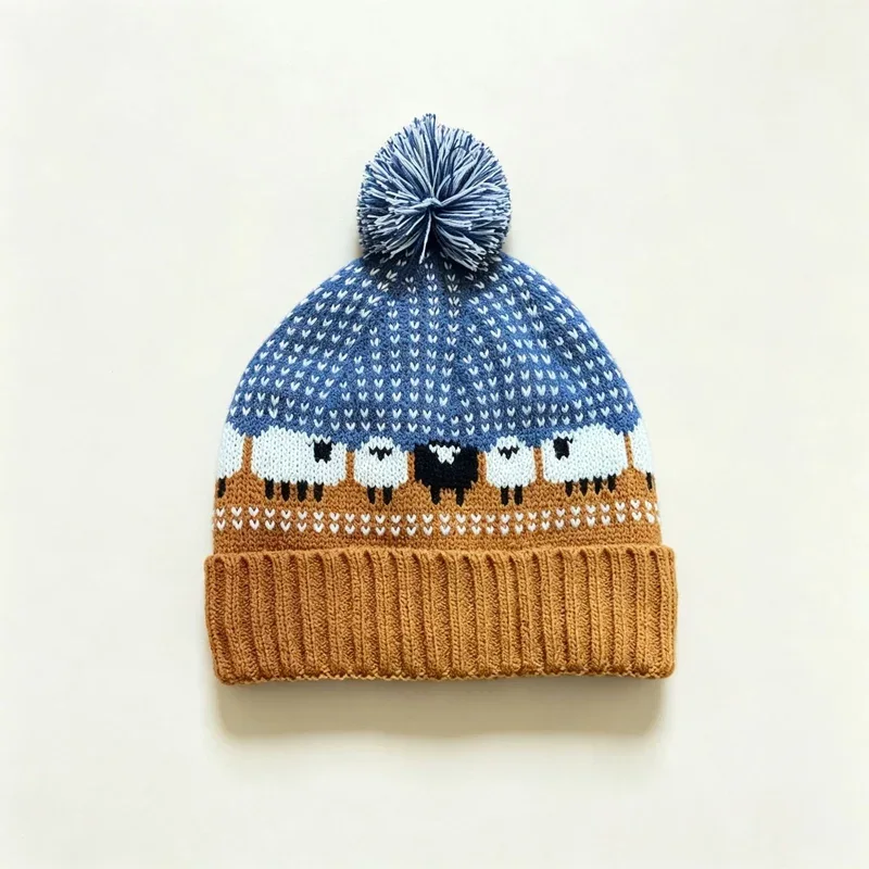 Blue and brown patterned knitted beanie with pom-pom