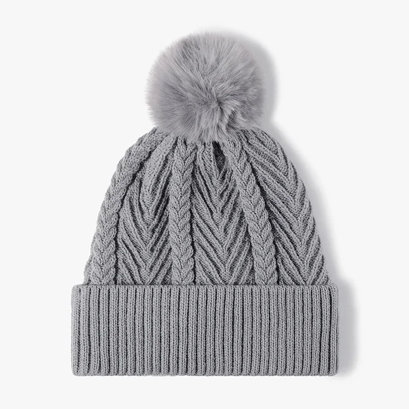 Blue-grey cable-knit beanie with a ribbed cuff and pom-pom