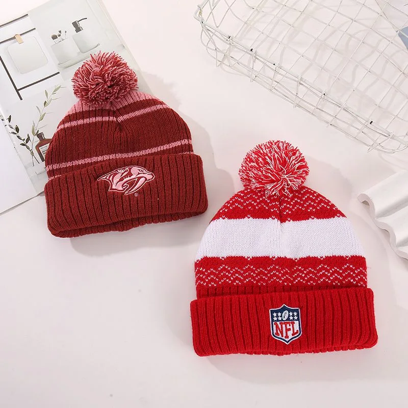 Burgundy and red striped pom pom beanies shown together