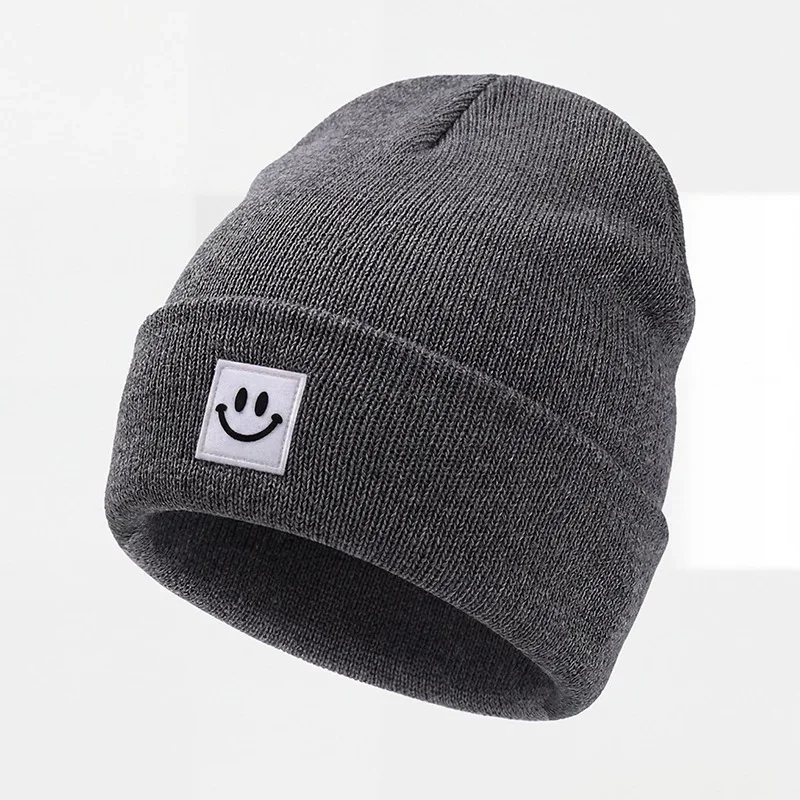 Charcoal cuffed knit beanie with a white square smile label