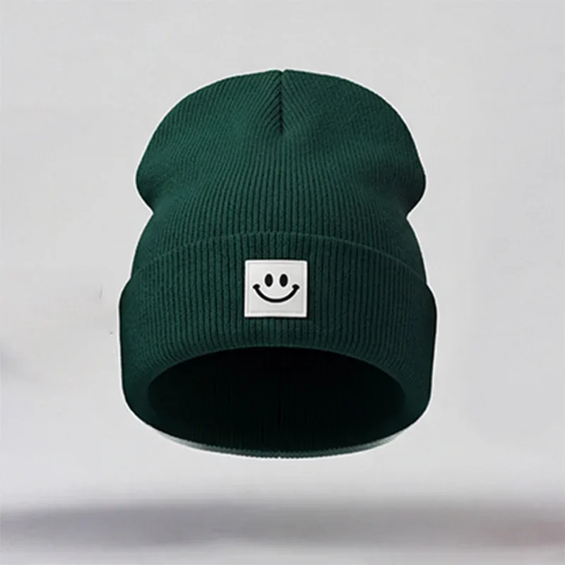 Dark green cuffed knit beanie with a white square smile label