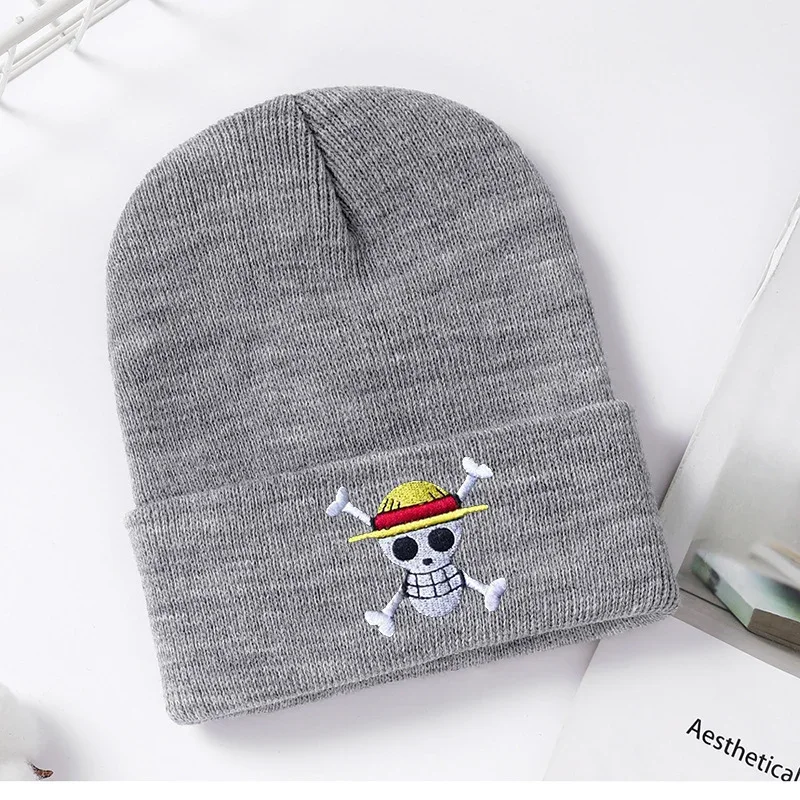 Grey knit beanie with a small skull and hat emblem