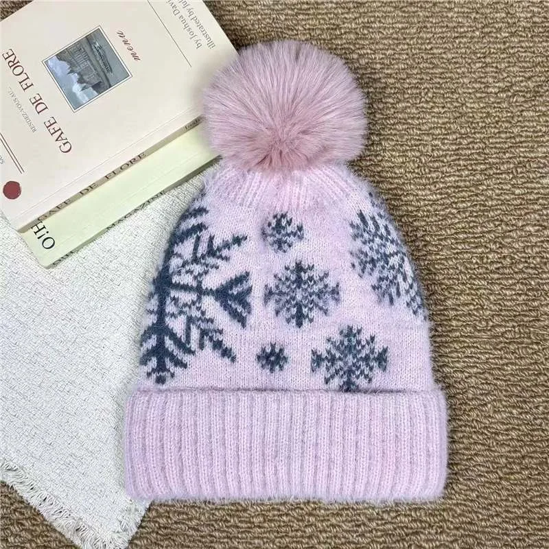 Lilac pom pom beanie with dark snowflake motifs and a folded cuff