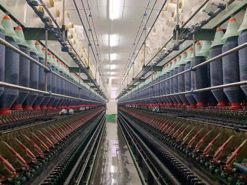 Long aisle of yarn processing equipment with rows of spools