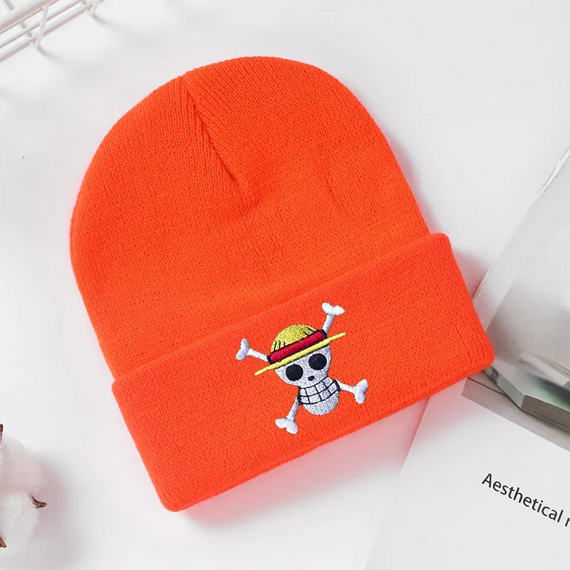 Orange cuffed knit beanie with a small skull and hat emblem