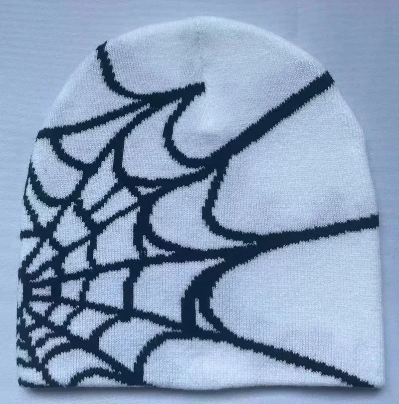 Pale blue knit beanie with a dark spiderweb motif