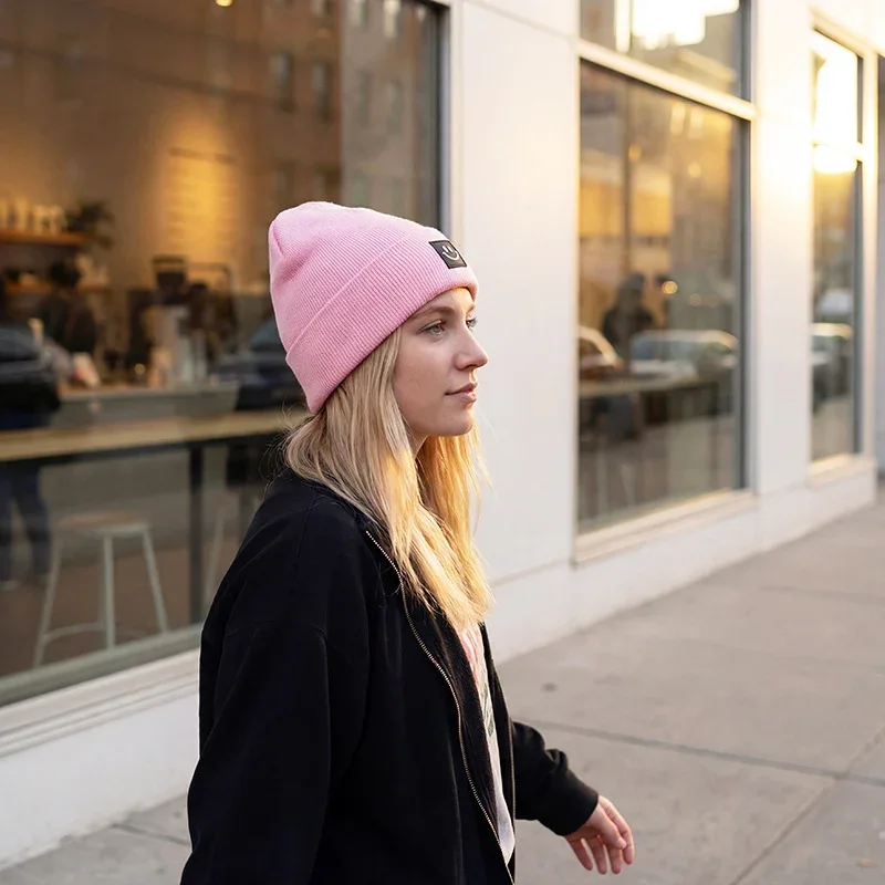 Pink cuffed beanie worn outdoors side view