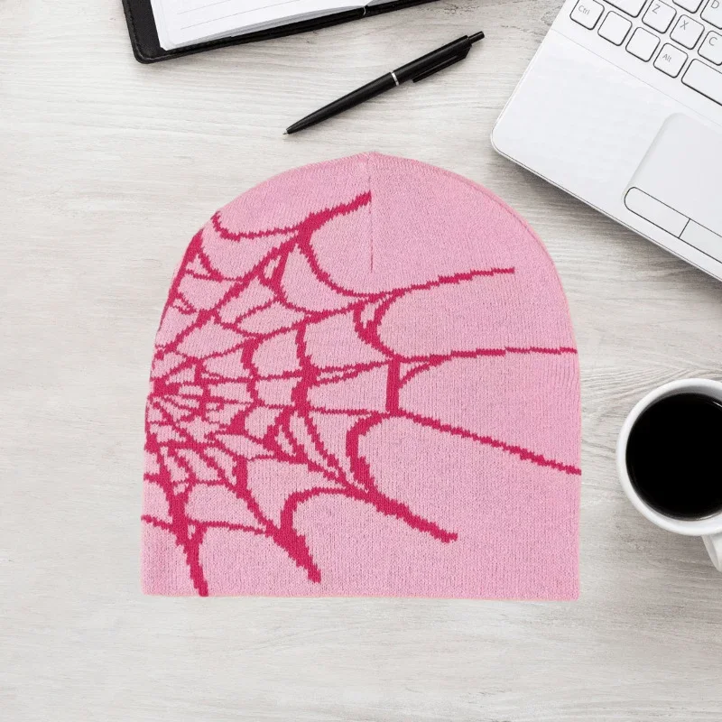 Pink knit beanie with a red spiderweb motif