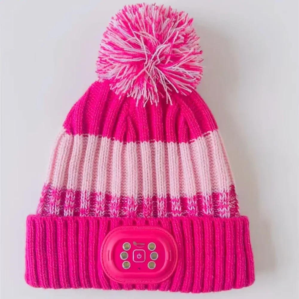 Pink striped pom pom beanie with a small light module on the folded