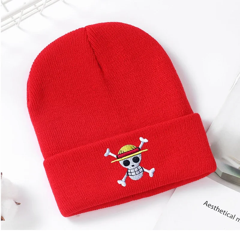 Red cuffed knit beanie with a small skull and hat emblem