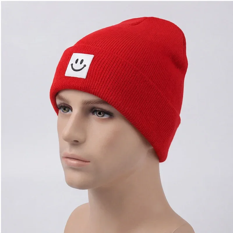 Red cuffed knit beanie with a white smile label on a mannequin