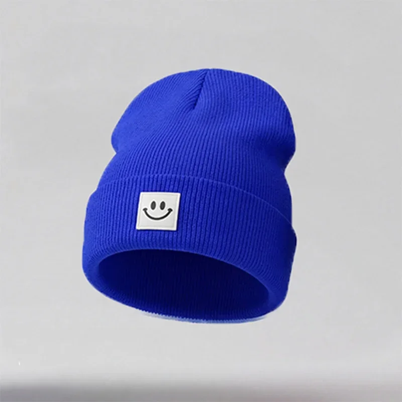 Royal blue cuffed knit beanie with a white square smile label