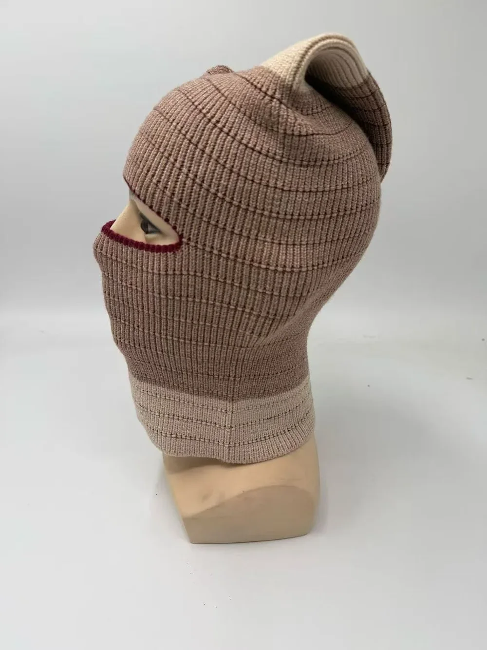 Taupe rib knit balaclava with a pointed crown and extended neck on a
