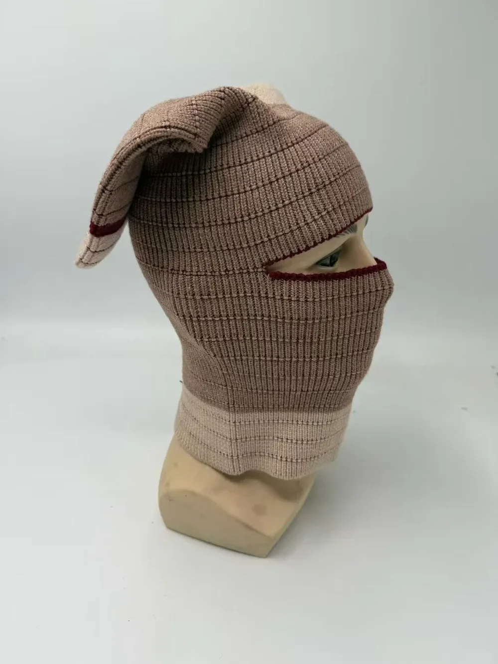Taupe rib knit balaclava with an eye opening and extended neck on a