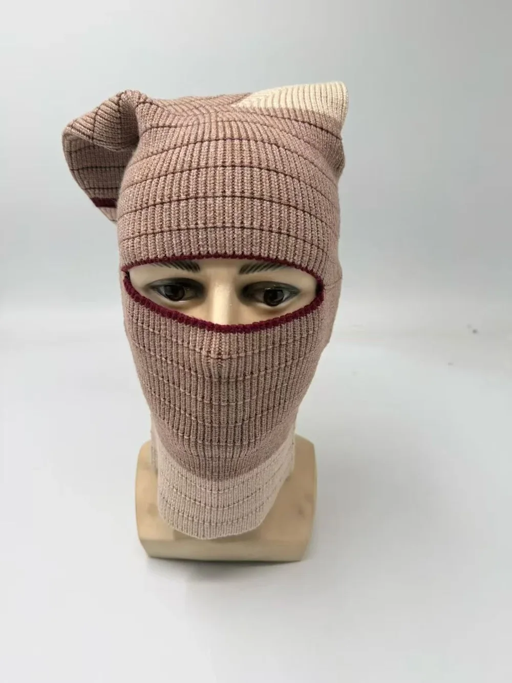 Taupe rib knit balaclava with an eye opening and pointed crown on a