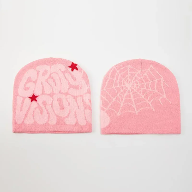Two pink knit beanies with cream lettering and web motifs